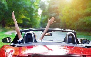 young woman driving red sports car