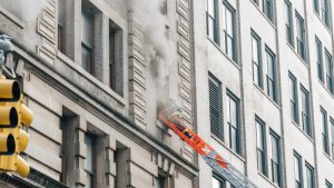 a high rise fire with a fireman on a ladder