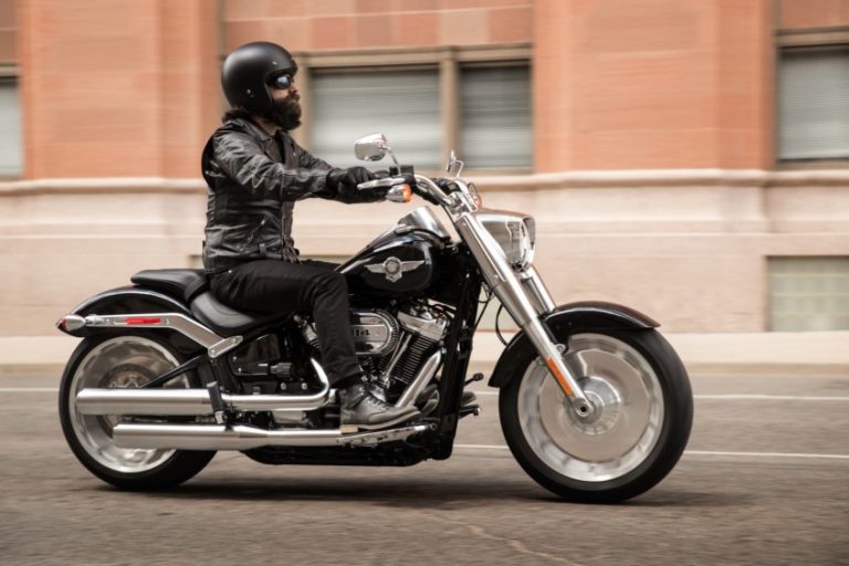 a man with a beard riding a harley davidson motorcycle