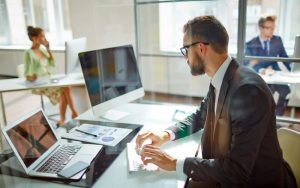 Young employee looking at computer monitor during working day in office